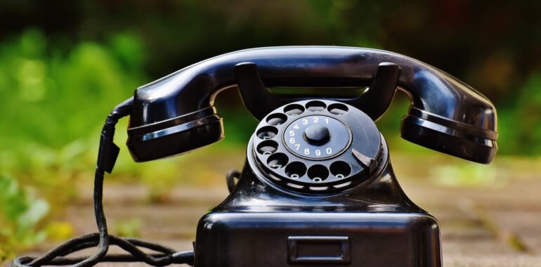 selective focus photography of black rotary phone