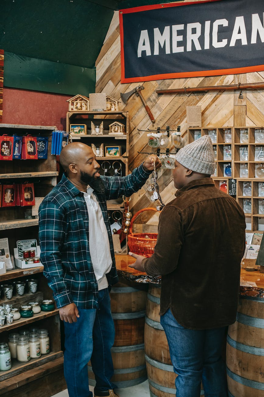 black father with unrecognizable son choosing souvenirs in local shop