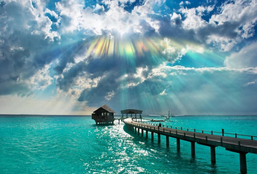 beautiful picture of doc going out into the water with the sun bursting through the clouds.