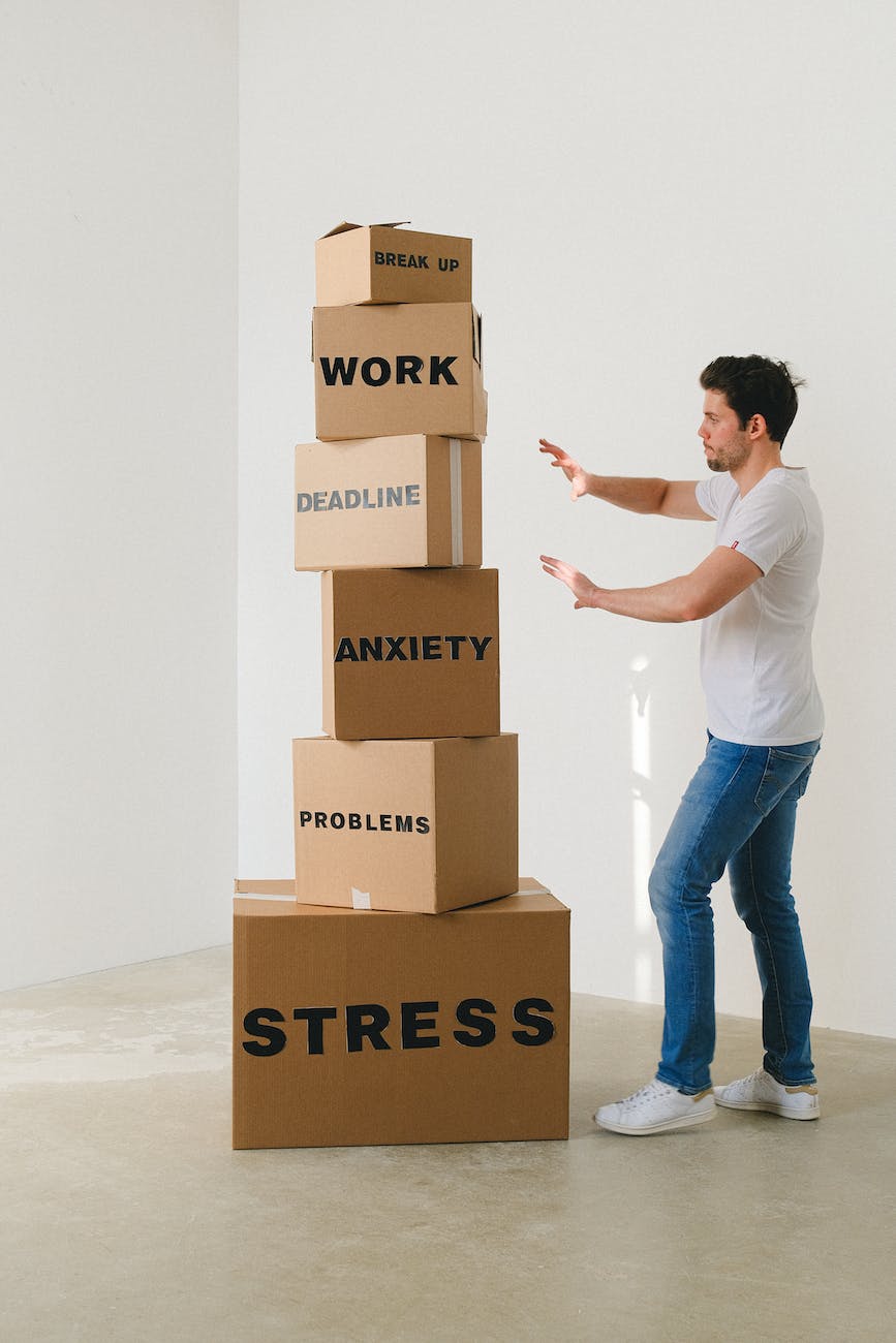 Overwhelmed and Tired man near carton boxes with many different words about stress