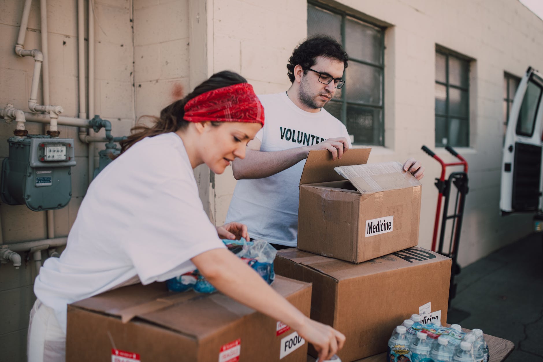 a man and a woman packing relief goods in boxes